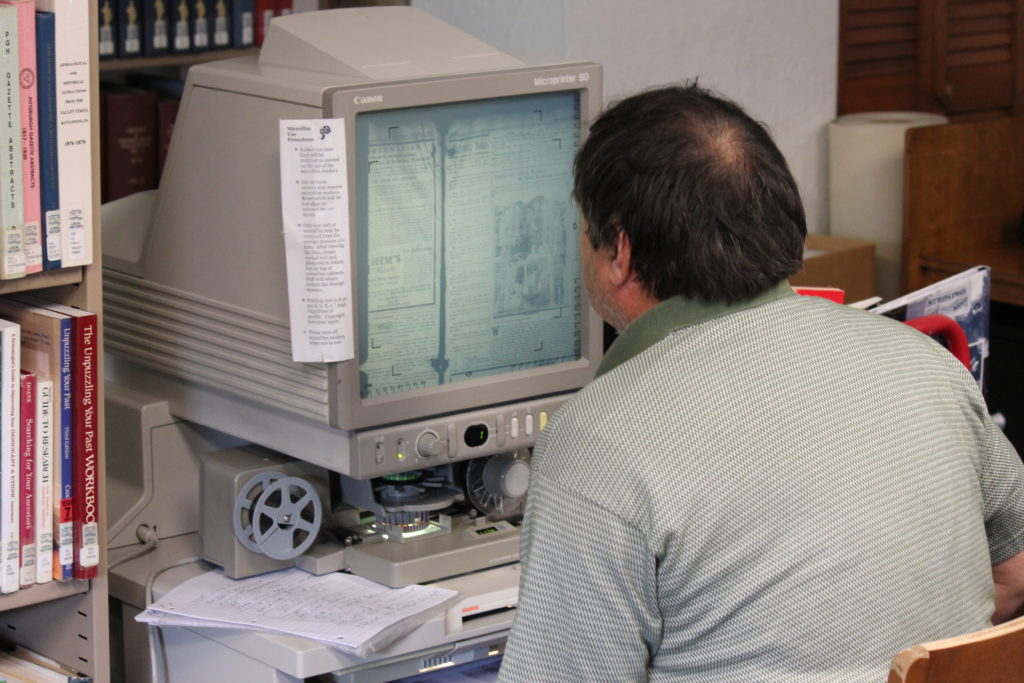 A researcher looking at microfilm