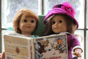 Two dolls reading a book