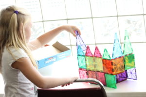 A girl building with plastic toys