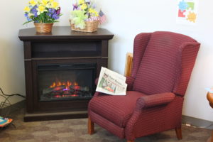 A comfy armchair near a fireplace for reading